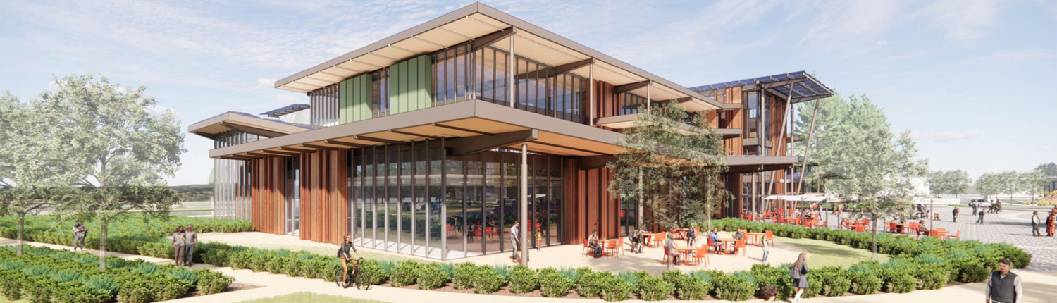 Main Library East Facing Rendering 3 View of the proposed Main Library looking east. A building overhang partially covers an outdoor patio area with tables and chairs bordered by landscaping.